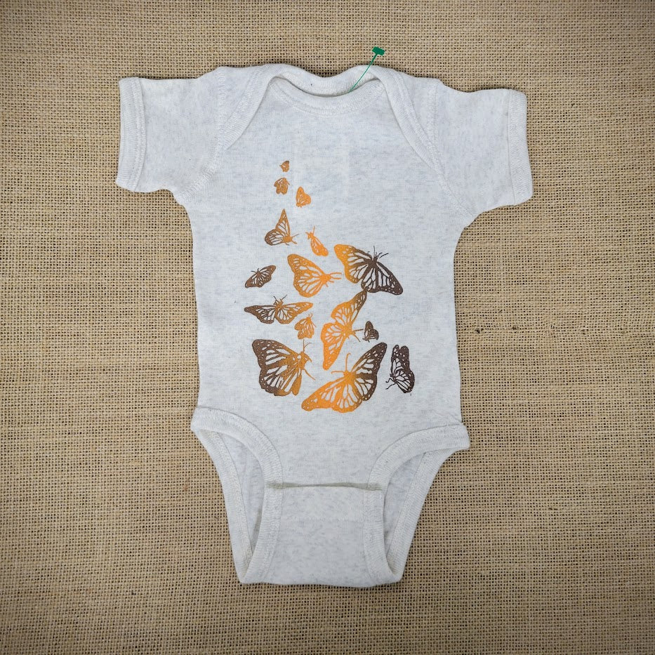 Oatmeal-colored baby onesie, with a brown & orange Monarch butterfly design across the front.