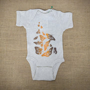 Oatmeal-colored baby onesie, with a brown & orange Monarch butterfly design across the front.