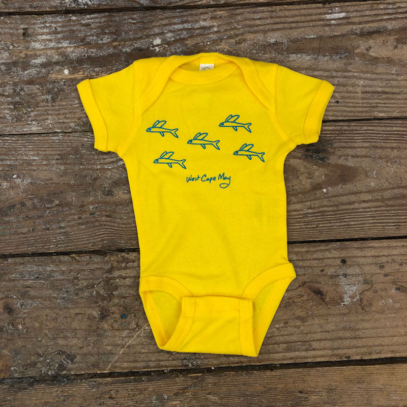 Bright yellow onesie featuring a 'Flying Fish Guppies' design on the front in blue ink.