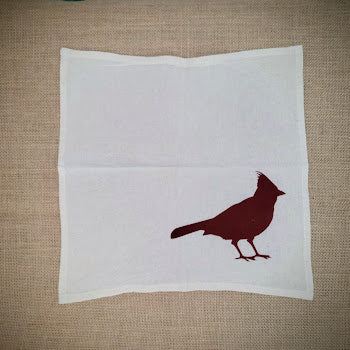 Flour sack napkin featuring the 'Cardinal' design on the bottom right in brick brown ink.