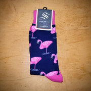 A pair of navy and pink socks with flamingos on them.