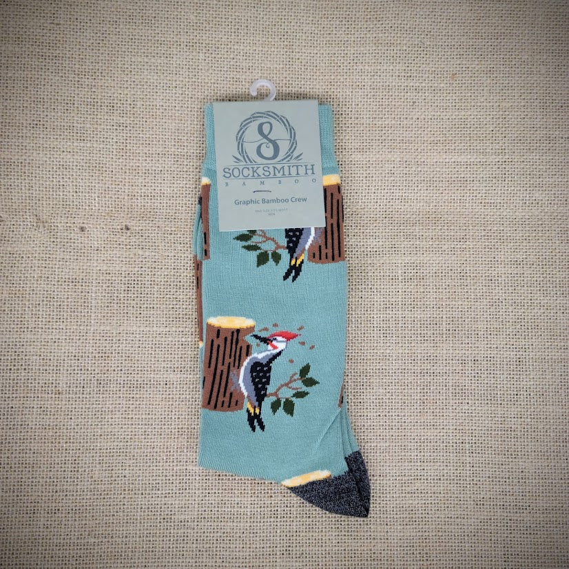 A pair of mint green socks with woodpeckers on them.