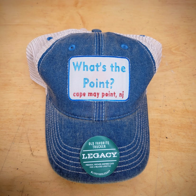 A blue and khaki, trucker hat with a 'What's the point?' patch on the front.