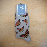 A pair of brown socks with butterflies on them.
