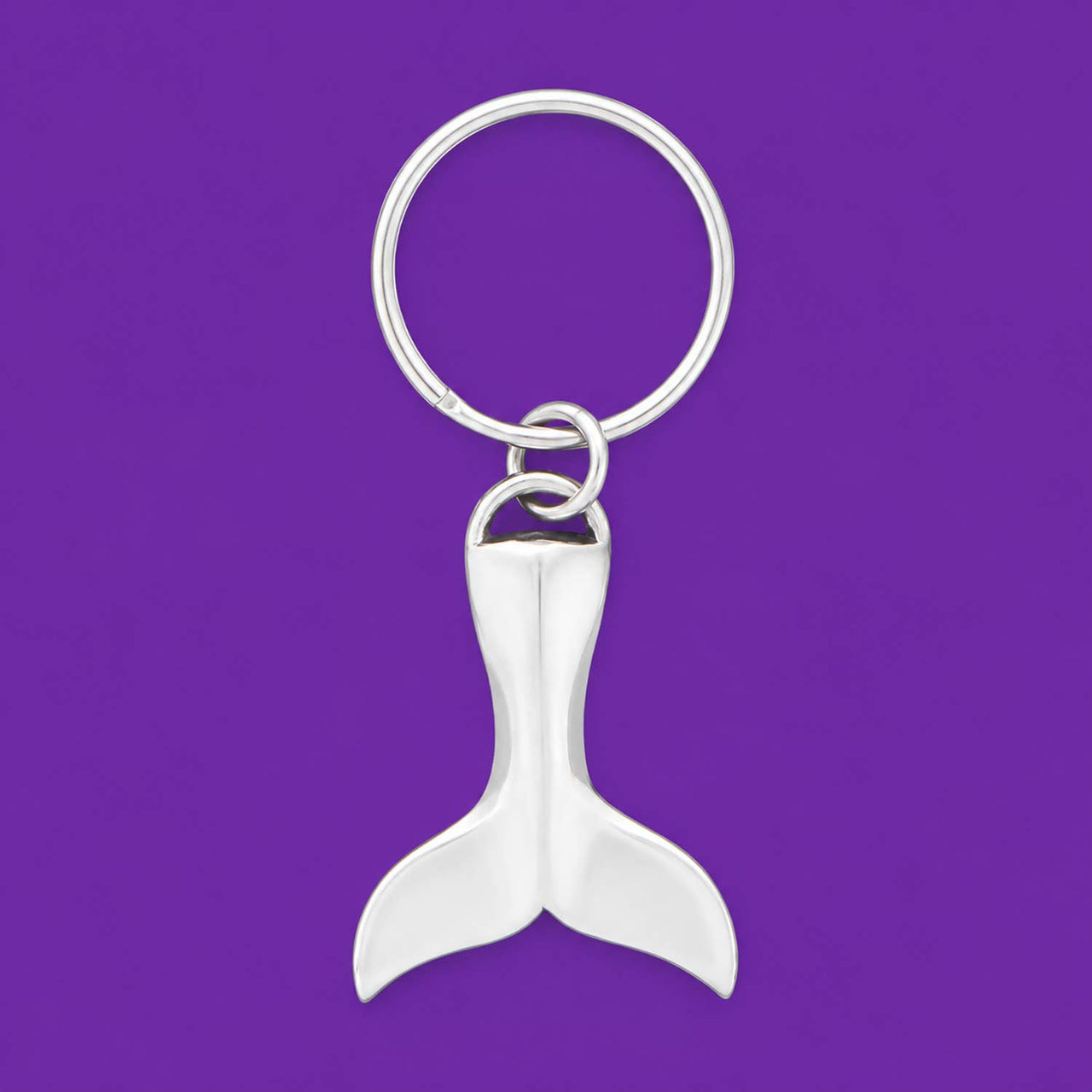 Whale tail keychain on a purple background.