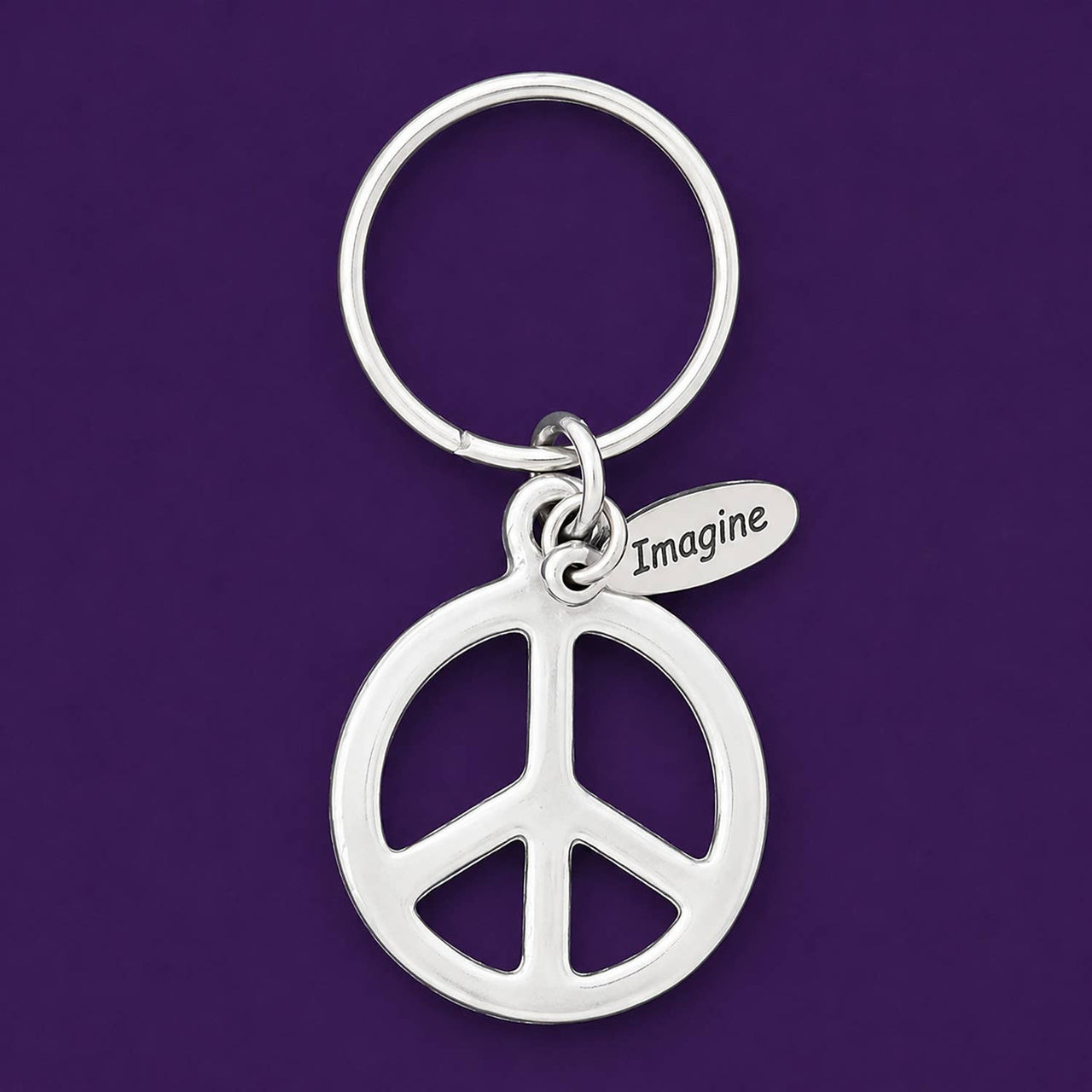Silver peace symbol keychain with 'Imagine' tag on a purple background.