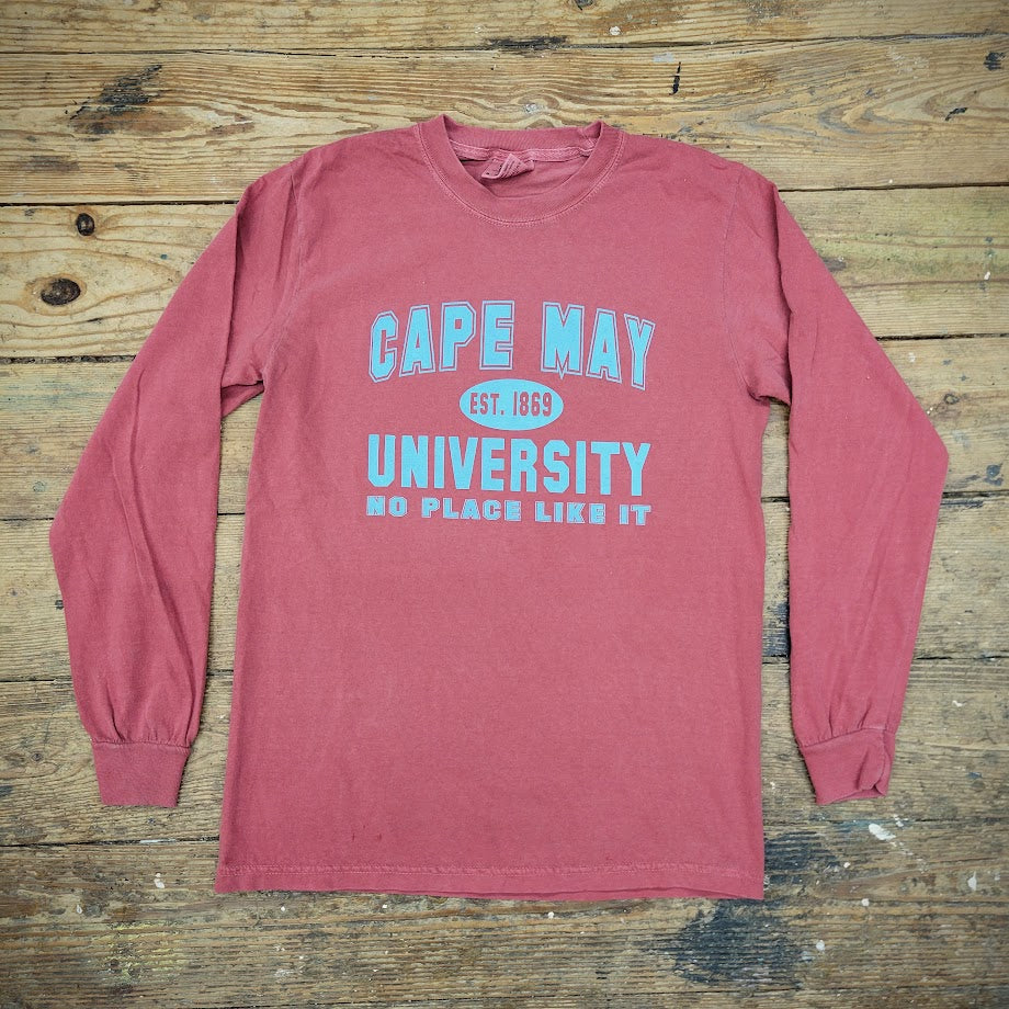 A long-sleeve, brick-red t-shirt with "CAPE MAY UNIVERSITY NO PLACE LIKE IT" printed in blue, centered on the chest.