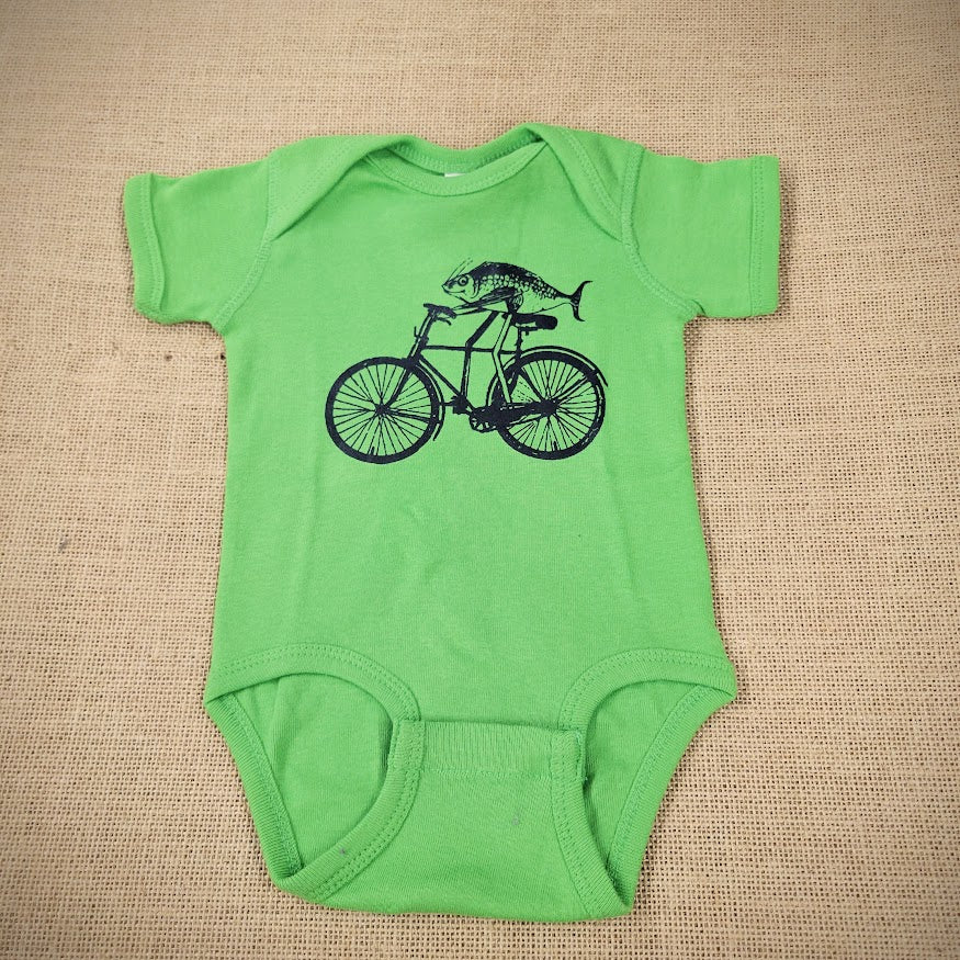 A green baby onesie with a graphic of a fish riding a bike.