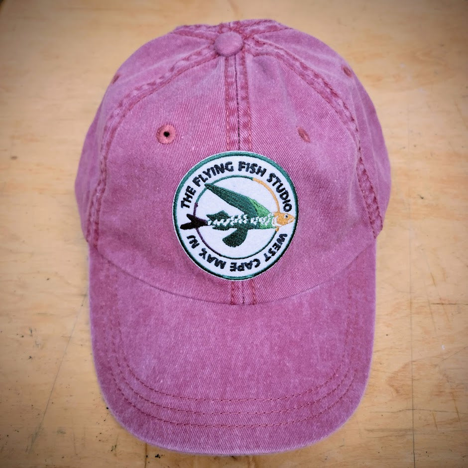 Red hat with a "Flying Fish Studio" patch ironed on the front.