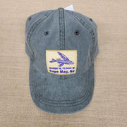Blue cap with a embroidered design on a beige fabric background.