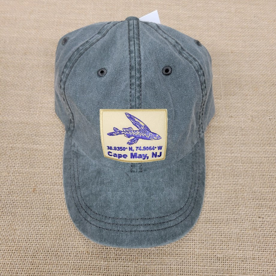 Blue cap with a embroidered design on a beige fabric background.