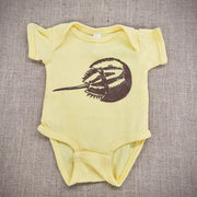 A buttery yellow baby onesie with a graphic of a horseshoe crab.