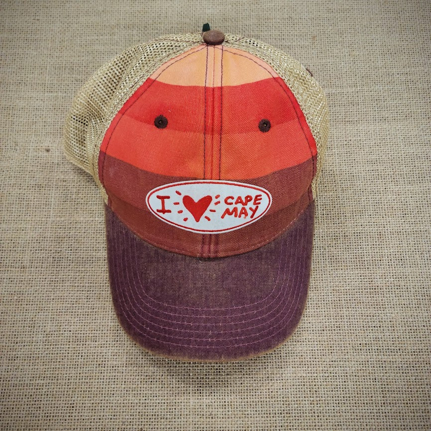 A multi-striped trucker hat with an oval patch that says, "I Heart Cape May"