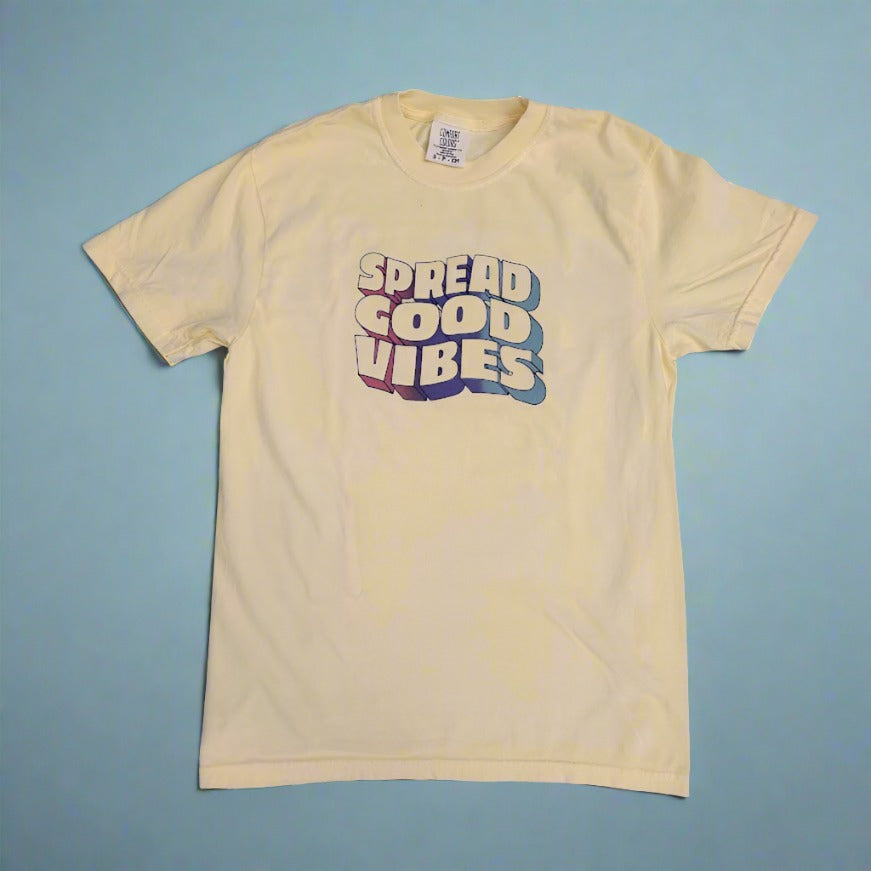 A yellow t-shirt with a graphic of "SPREAD GOOD VIBES" on the front.