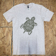 Gray, heathered T-shirt with a turtle design in green on the front, laid flat on a wooden surface.