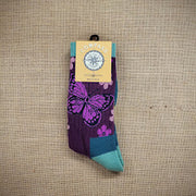 A pair of purple & blue wool socks with butterflies & flowers on them.