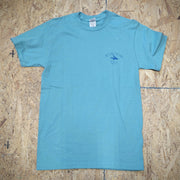 Greenish-blue T-shirt with the 'Flying Fish Studio' logo on the left chest on a wooden surface.