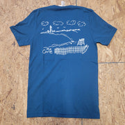 Image of a deep blue T-shirt with a white graphic design of a beach and text that says 'The Cove', laid flat on a wooden surface.