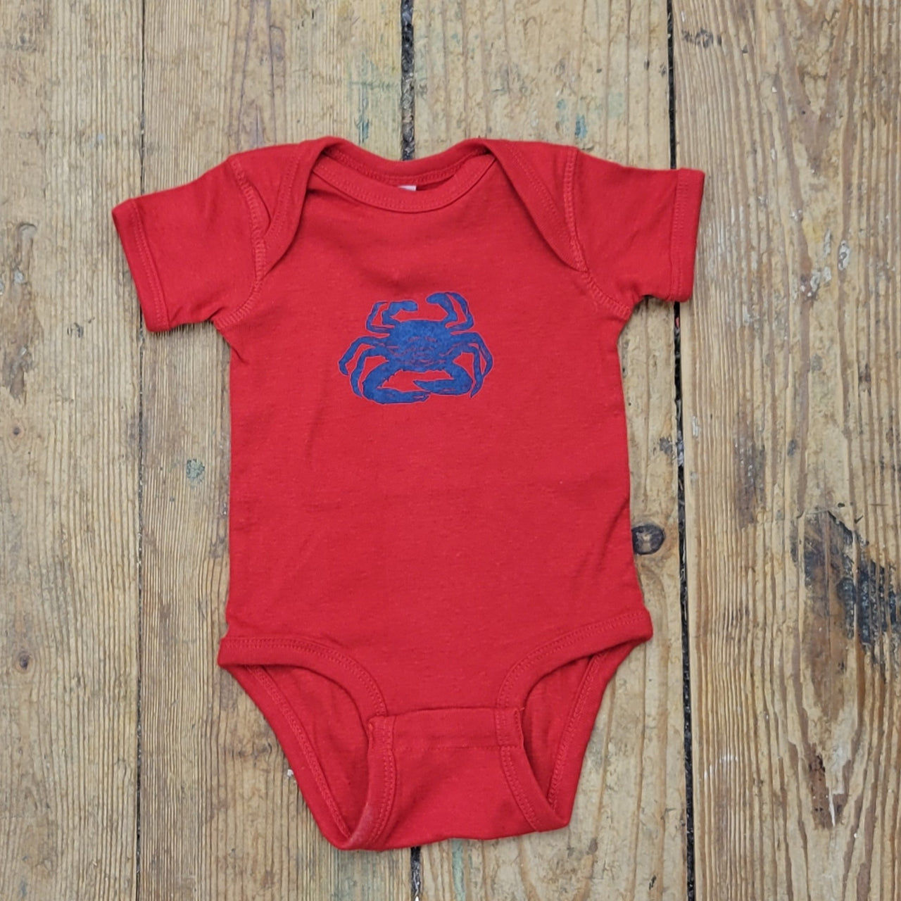 Bright red onesie featuring a 'Crab' design in royal blue ink.
