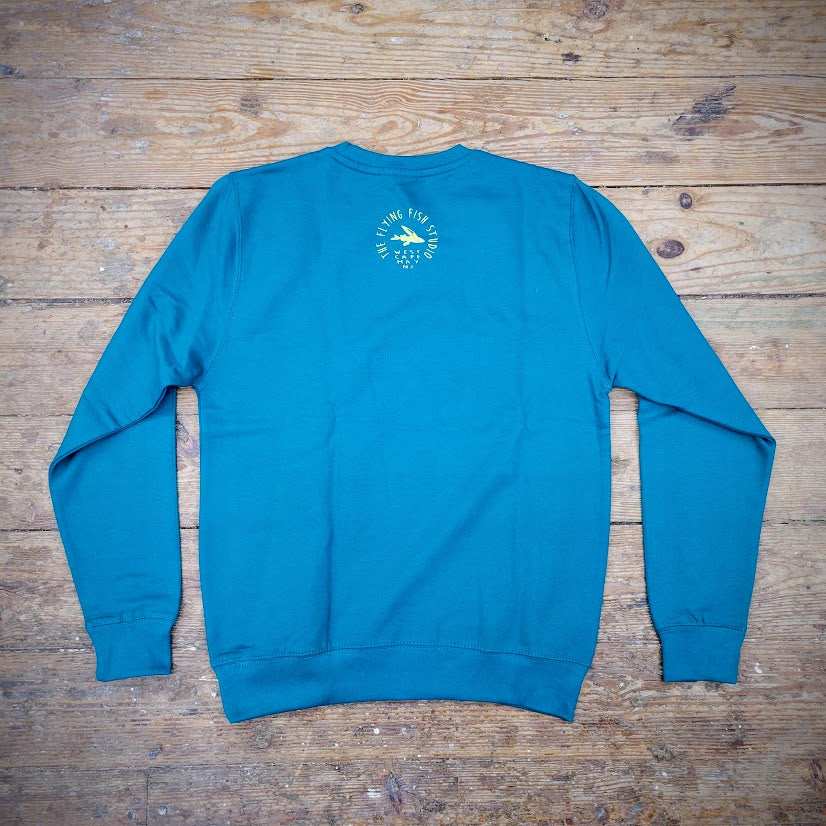 A blue sweatshirt with the 'Flying Fish Studio' logo on the back neck in butter yellow ink.