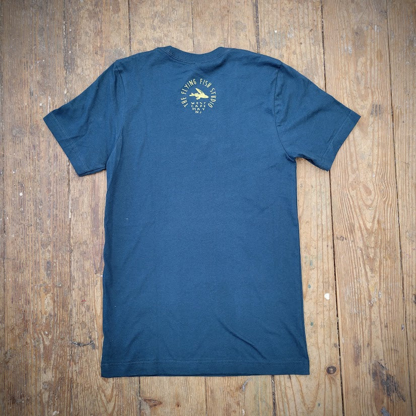 A blue t-shirt with the 'Flying Fish Studio' logo on the back neck in butter yellow ink.