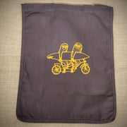 A brown grocery tote with two yellow sloths riding a tandem on it.