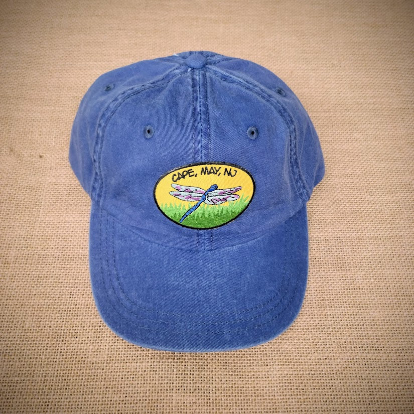 A blue, classic dad hat with a dragonfly patch on it.