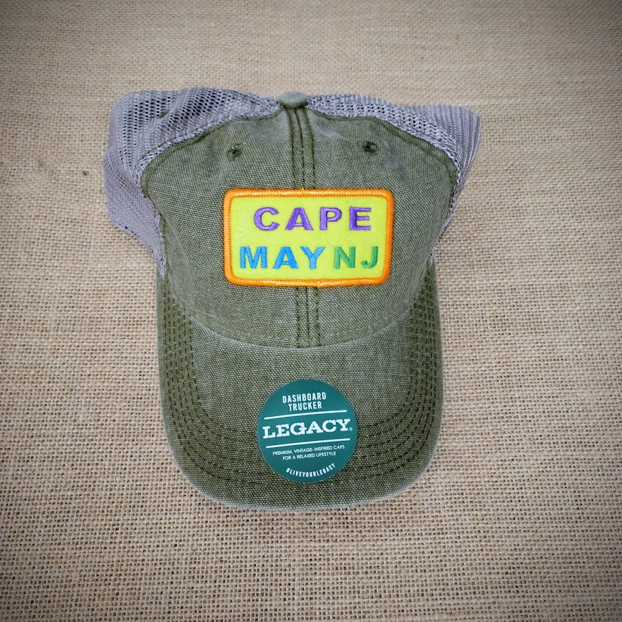 A green and khaki trucker hat with a 'West Cape May' patch on it.