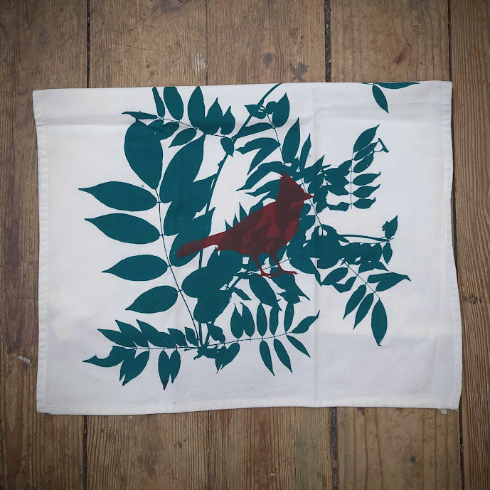 White, flour sack tea towel featuring the 'Cardinal' design in brick brown and green.