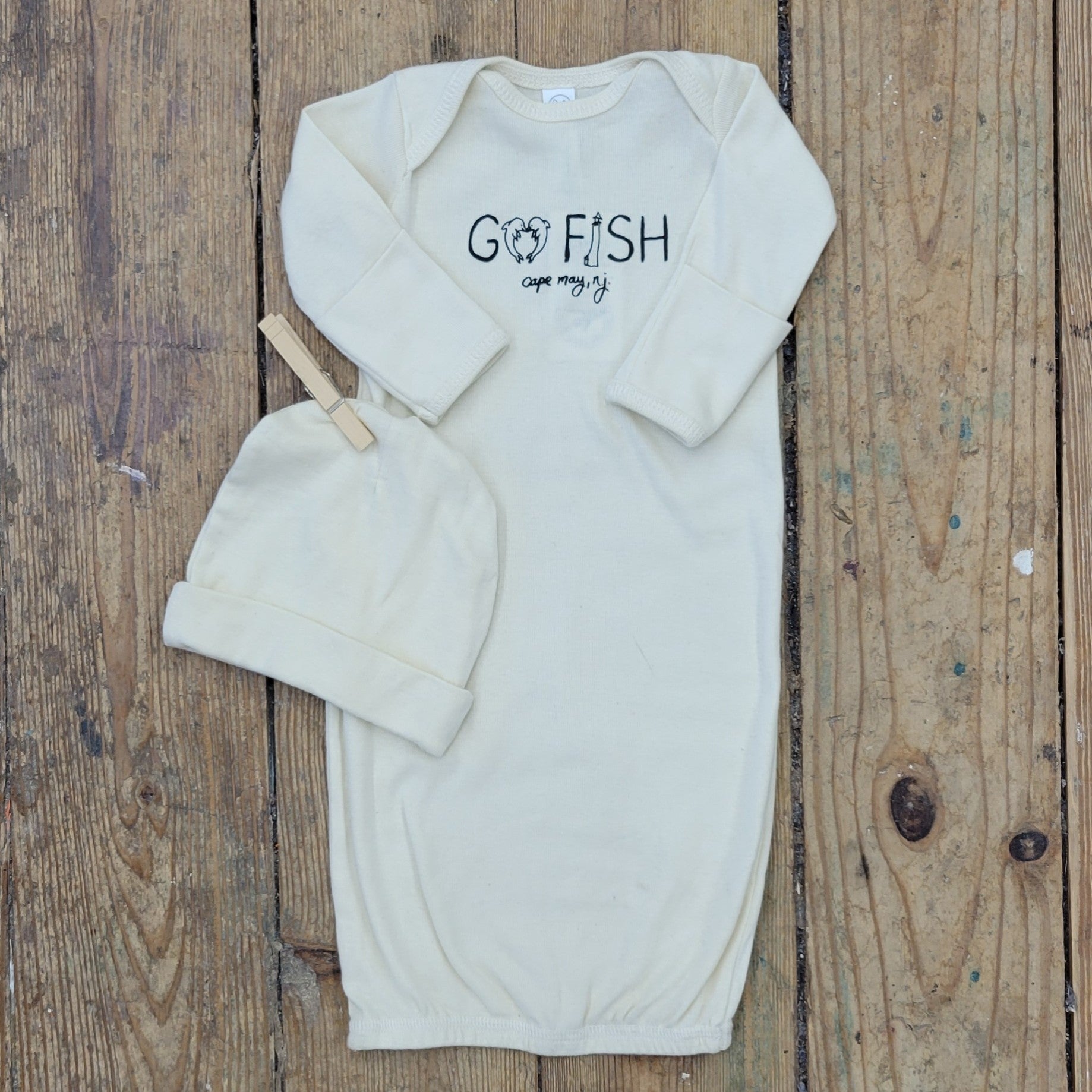 Cream layette featuring a 'Go Fish! Cape May' design on the front in black ink.