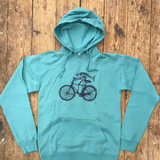 Seafoam Green hoodie featuring a 'Fish on a Bike' design on the front in navy ink.