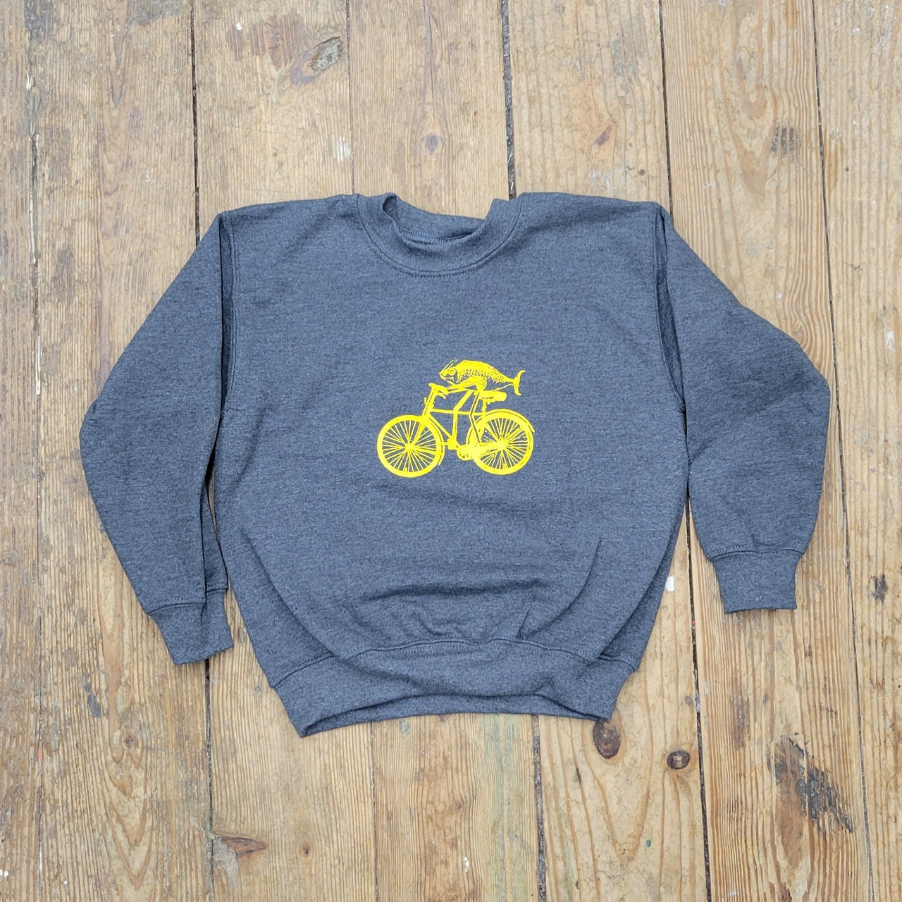 A dark grey sweatshirt with a yellow 'Fish on a Bike' design on the front.