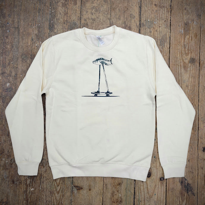 A cream sweatshirt with a teal 'Fish on a Skateboard' design on the front.