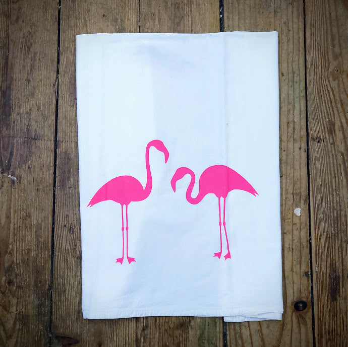 White. flour sack tea towel featuring the 'Lynn's Flamingos' design in hot pink ink.
