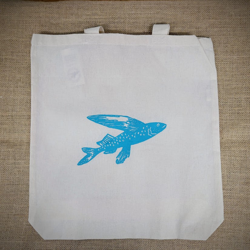 Natural, canvas tote bag with a light blue flying fish in the front.