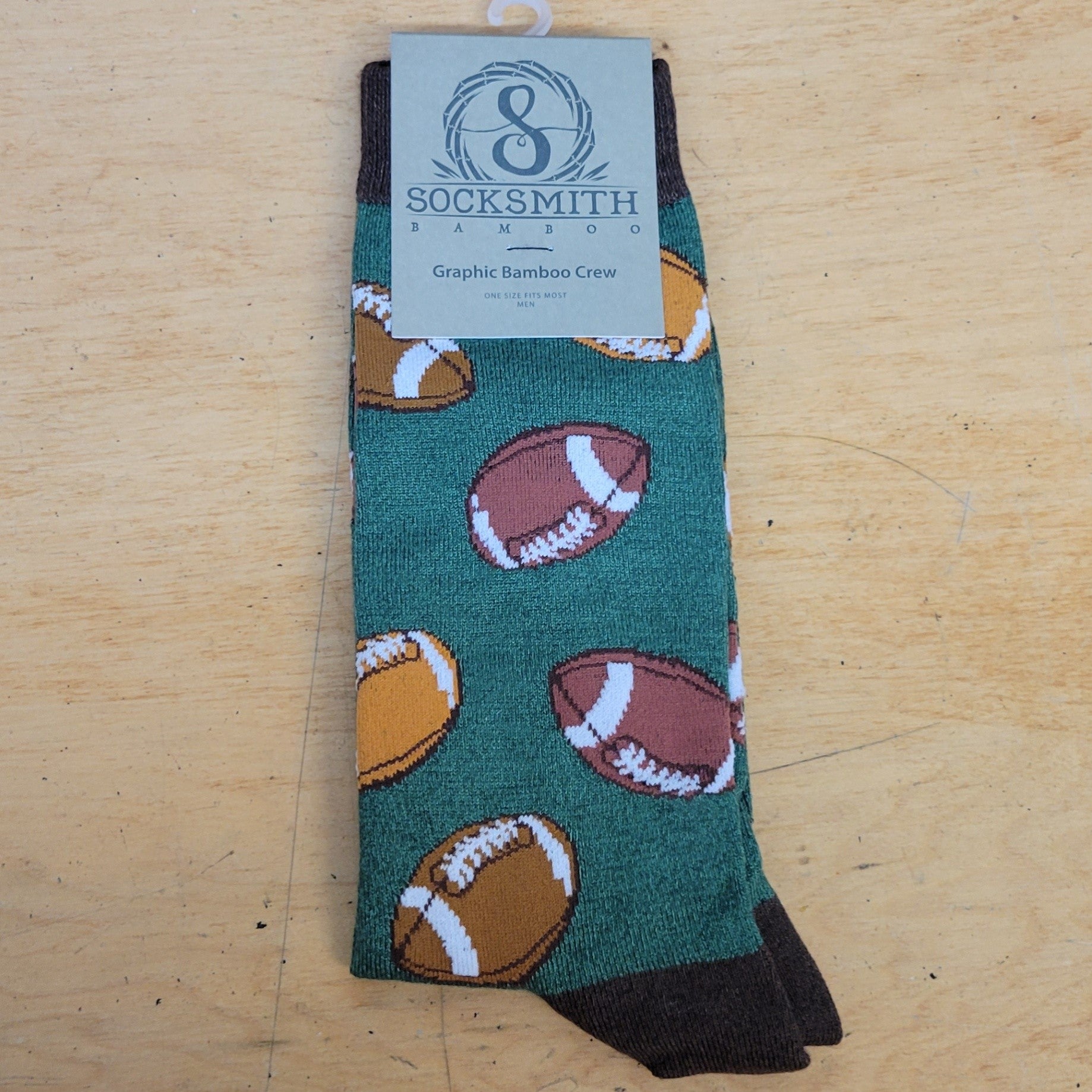 A green pair of socks with footballs on them.