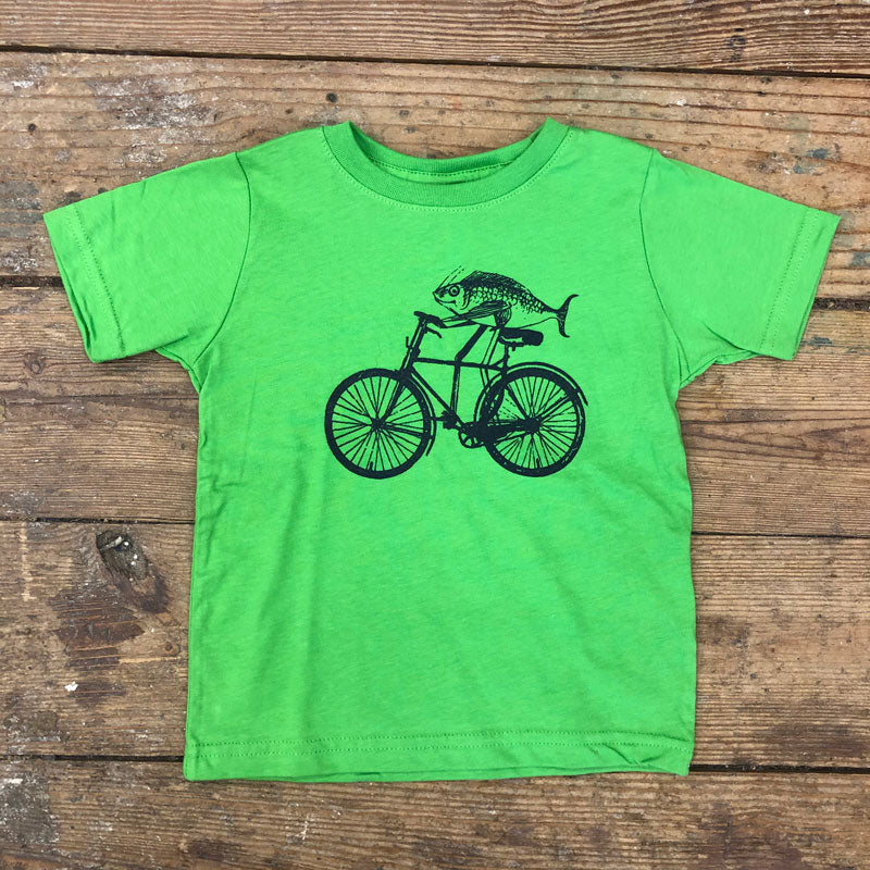 A green t-shirt featuring a fish on a bike on the front in navy ink.