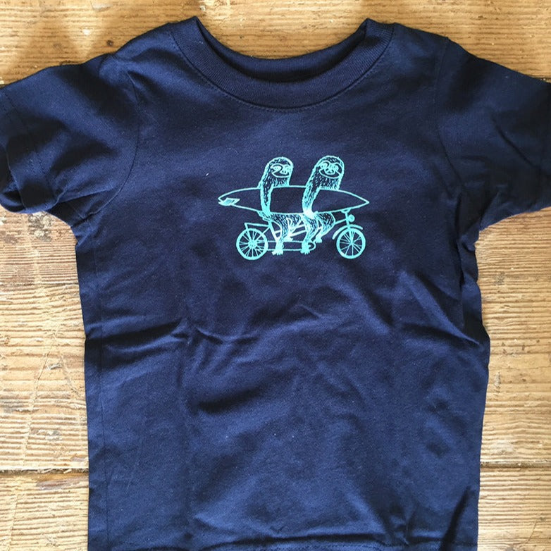 A navy t-shirt featuring two sloths riding a tandem bike on the front chest.