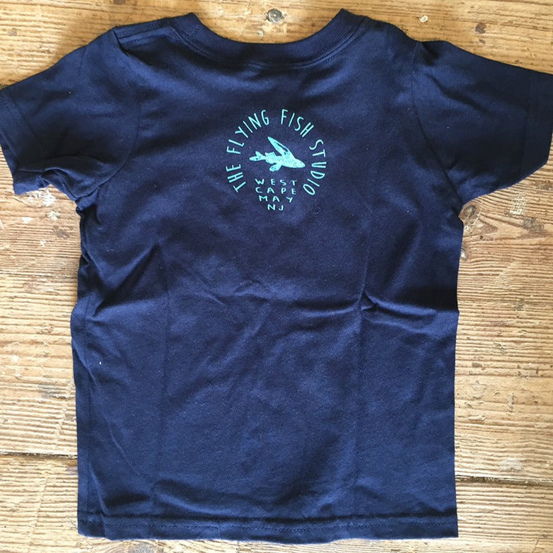 A navy t-shirt featuring the 'Flying Fish Studio' logo on the back neck in light blue ink.