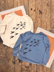 Two of the 'Flying Fish' sweatshirts in bone cream and misty blue.