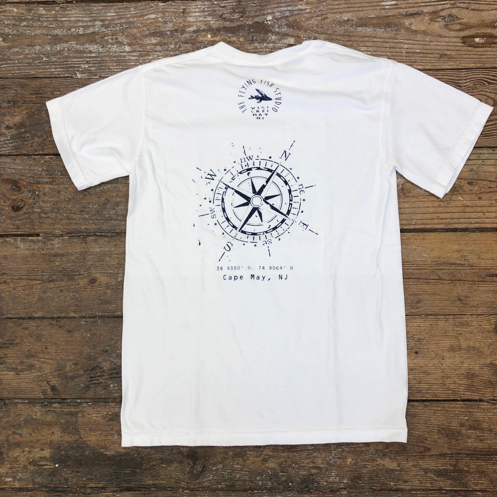 A white t-shirt with a 'Compass' design on the back.