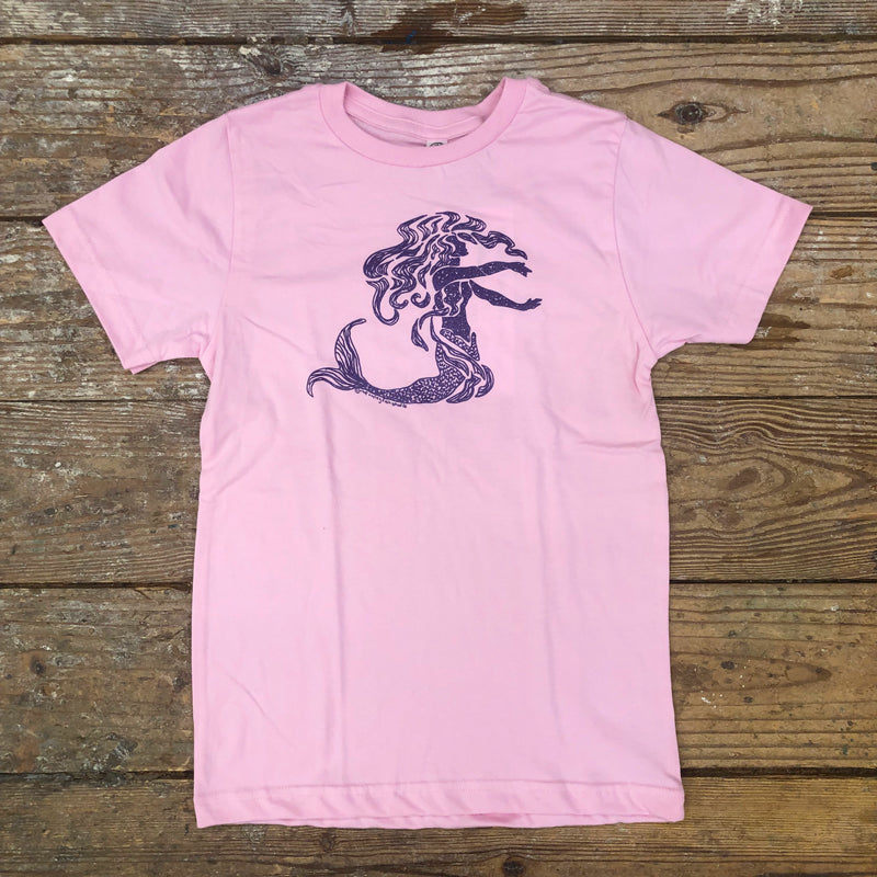 A pink t-shirt featuring a shimmery purple mermaid on the front chest.