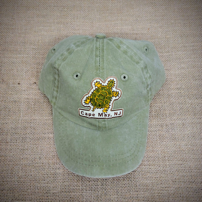 Khaki hat with a turtle patch ironed on the front.