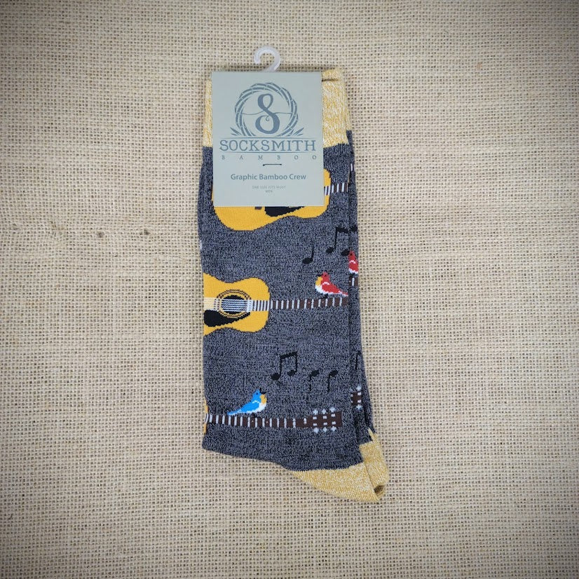 A pair of grey socks with birds and acoustic guitars on them.