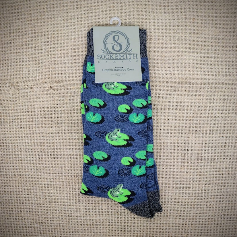 A blue pair of socks with frogs and lily pads on them.