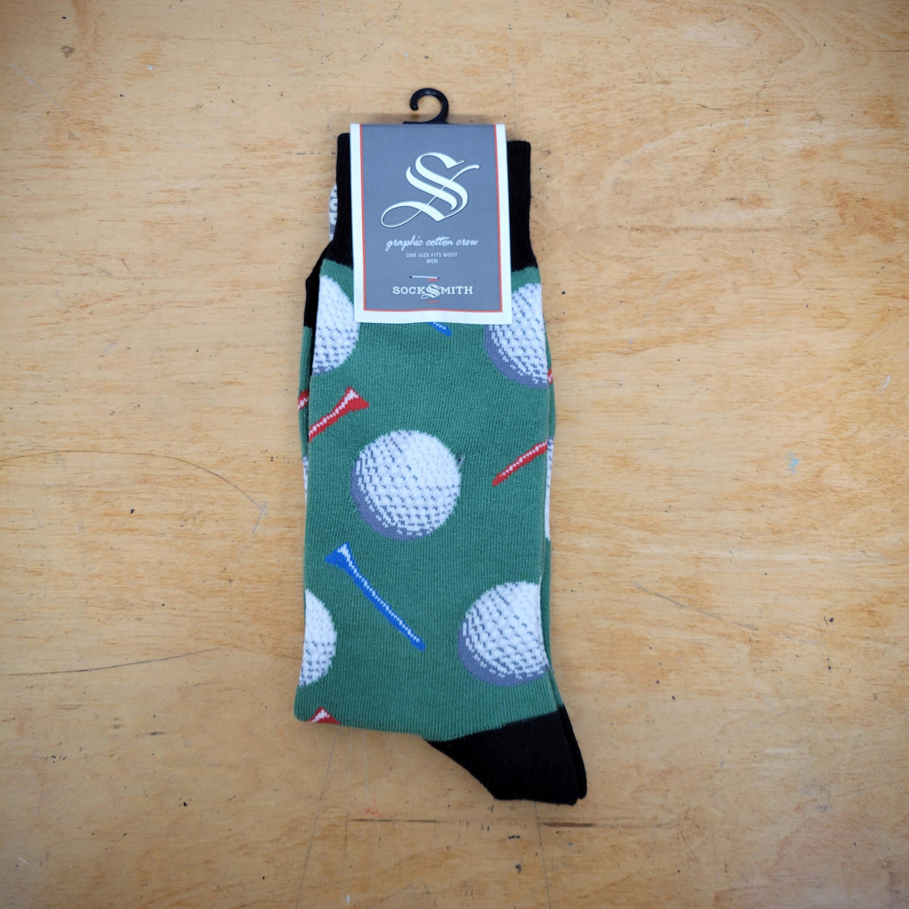 A pair of green socks with golf balls on them.