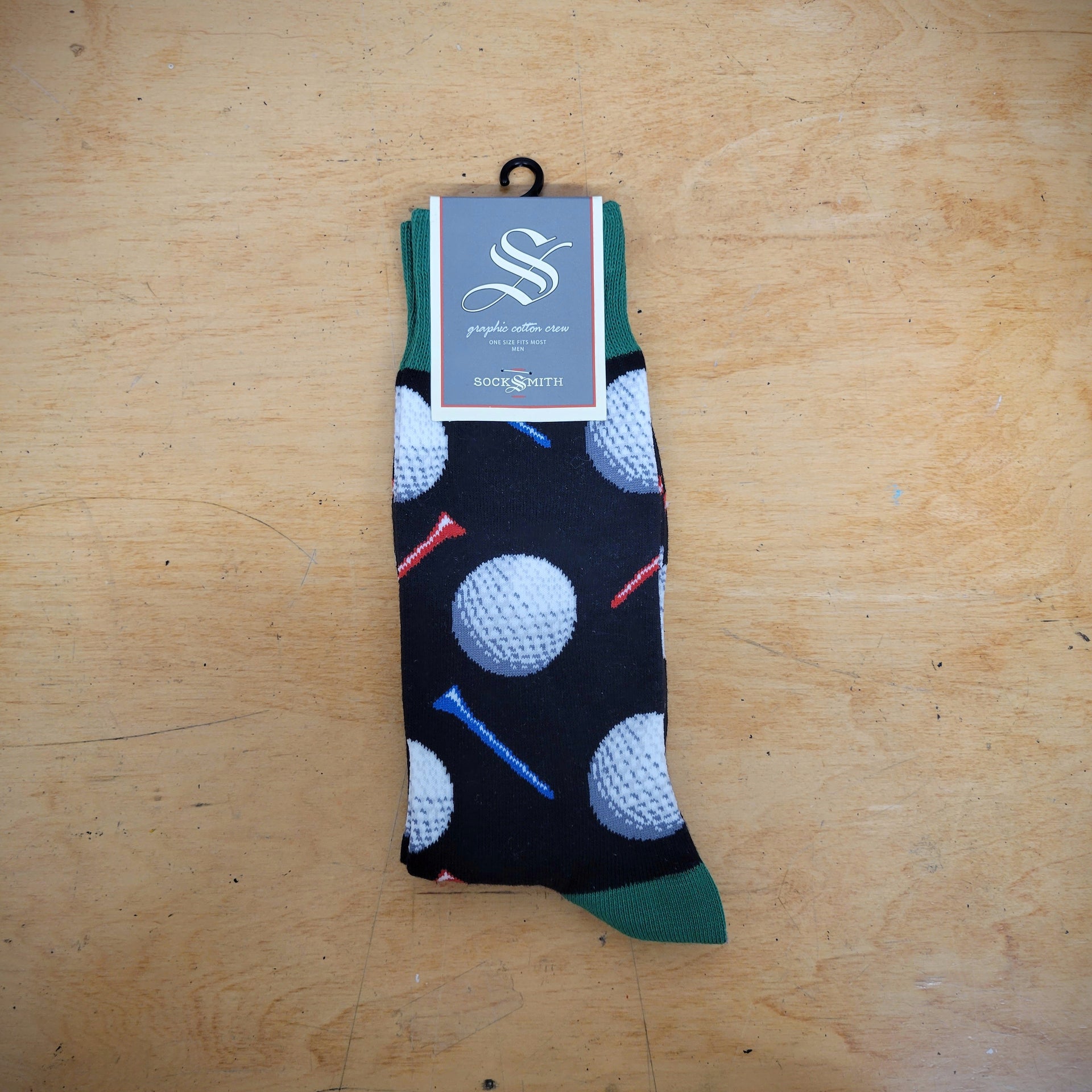 A pair of black socks with golf balls on them.