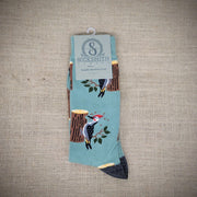 A pair of mint green socks with woodpeckers on them.