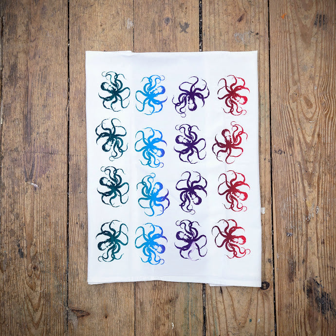 White, flour sack tea towel featuring multi-colored octopi in a gradient ink.