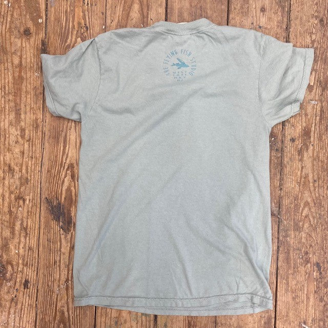 A greenish-blue t-shirt with the 'Flying Fish Studio' design on the back neck in teal ink.